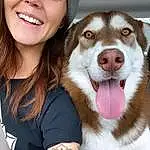 Skin, Smile, Dog, Facial Expression, Carnivore, Dog breed, Gesture, Happy, Fawn, Companion dog, Hat, Snout, Whiskers, Wrist, Furry friends, Cap, Brown Hair, Sled Dog, Canidae